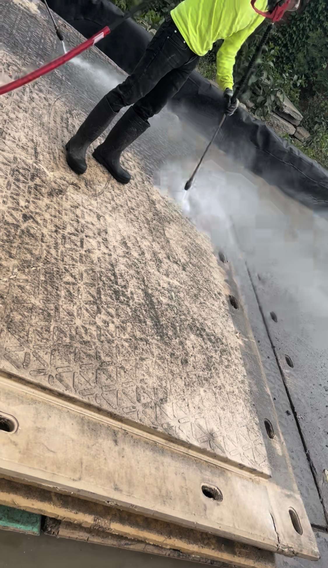 MatPRO technician pressure washing and refurbishing a composite mat — the patented process